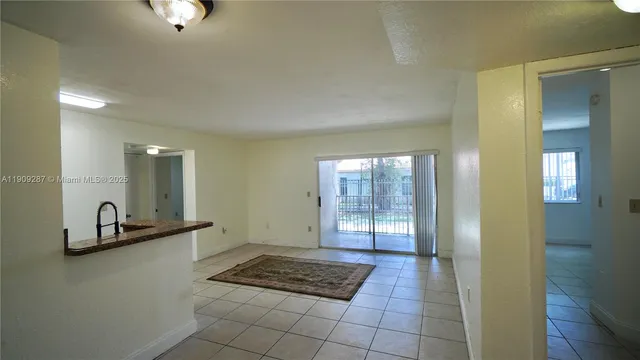a view of a hallway to a room with windows