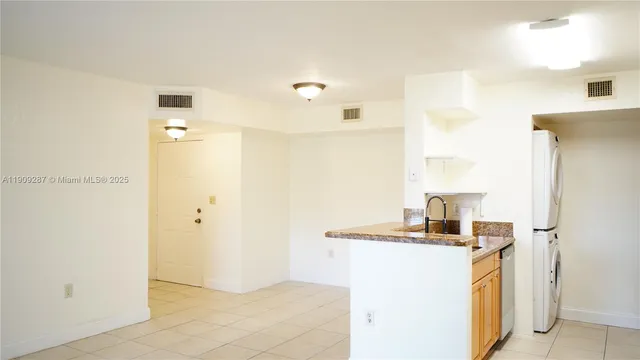 a kitchen with stainless steel appliances granite countertop a sink and a refrigerator
