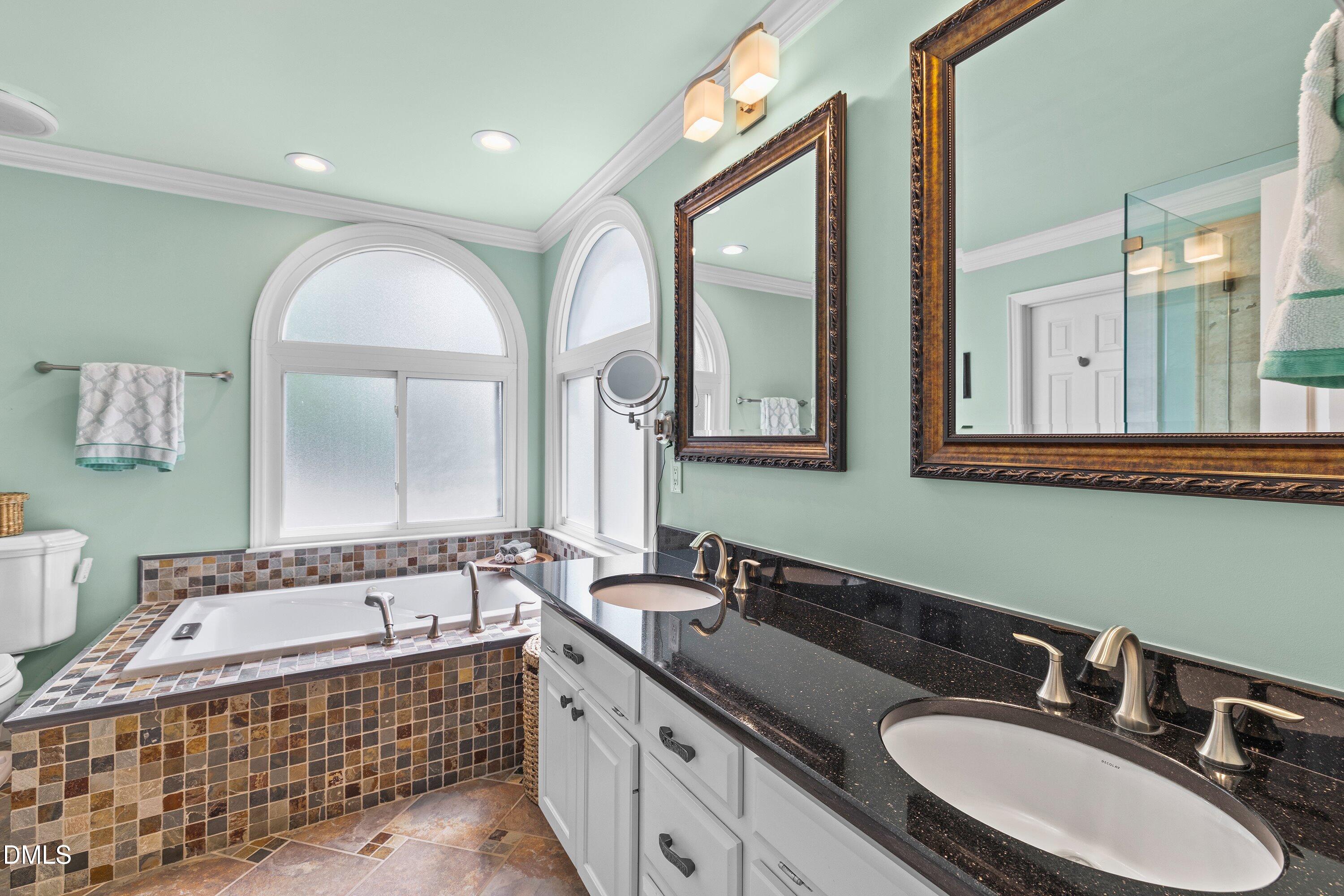 6612 Fowler Road Zebulon, NC 27597 - Photo 25 of 42 a bathroom with a sink double vanity mirror and a bathtub
