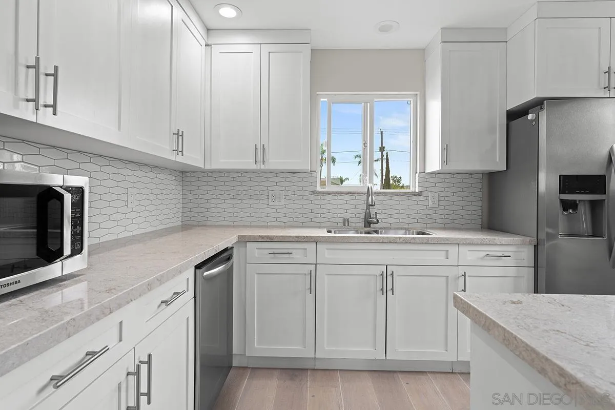 3539 Granada Avenue San Diego, CA 92104 - Photo 12 of 35 a kitchen with white cabinets sink and stainless steel appliances