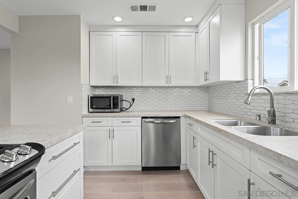 3539 Granada Avenue San Diego, CA 92104 - Photo 14 of 35 a kitchen with white cabinets sink and stove