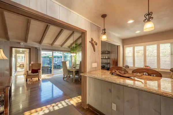 a view of a dining room and livingroom with furniture wooden floor a chandelier