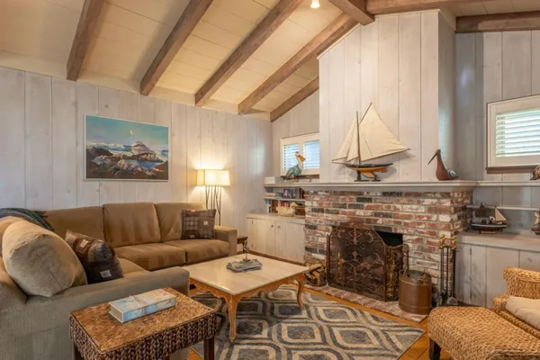 a living room with furniture a fireplace and a large window