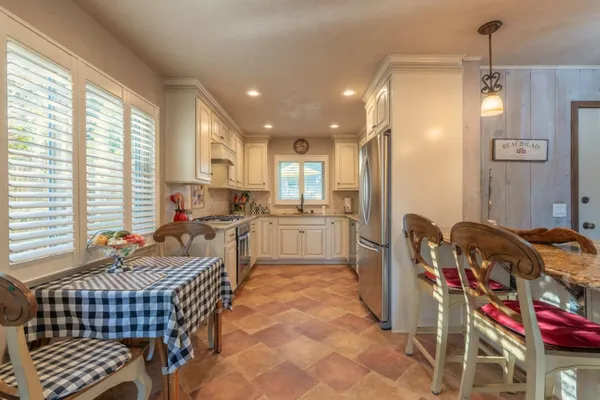 a kitchen with stainless steel appliances granite countertop a sink a stove and cabinets
