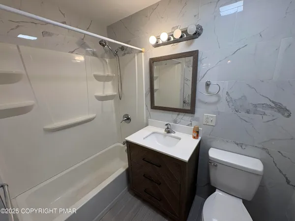 a bathroom with a sink toilet vanity and tub
