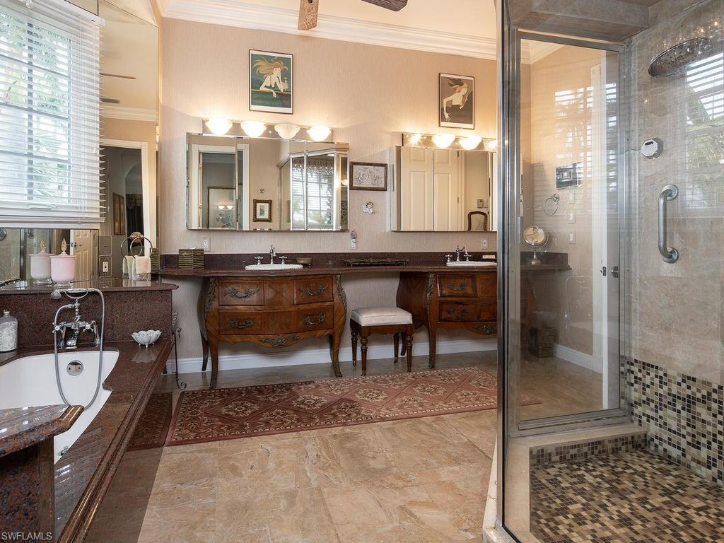 720 17th Avenue South Naples, FL 34102 - Photo 13 of 33 a bathroom with a sink a mirror and a shower