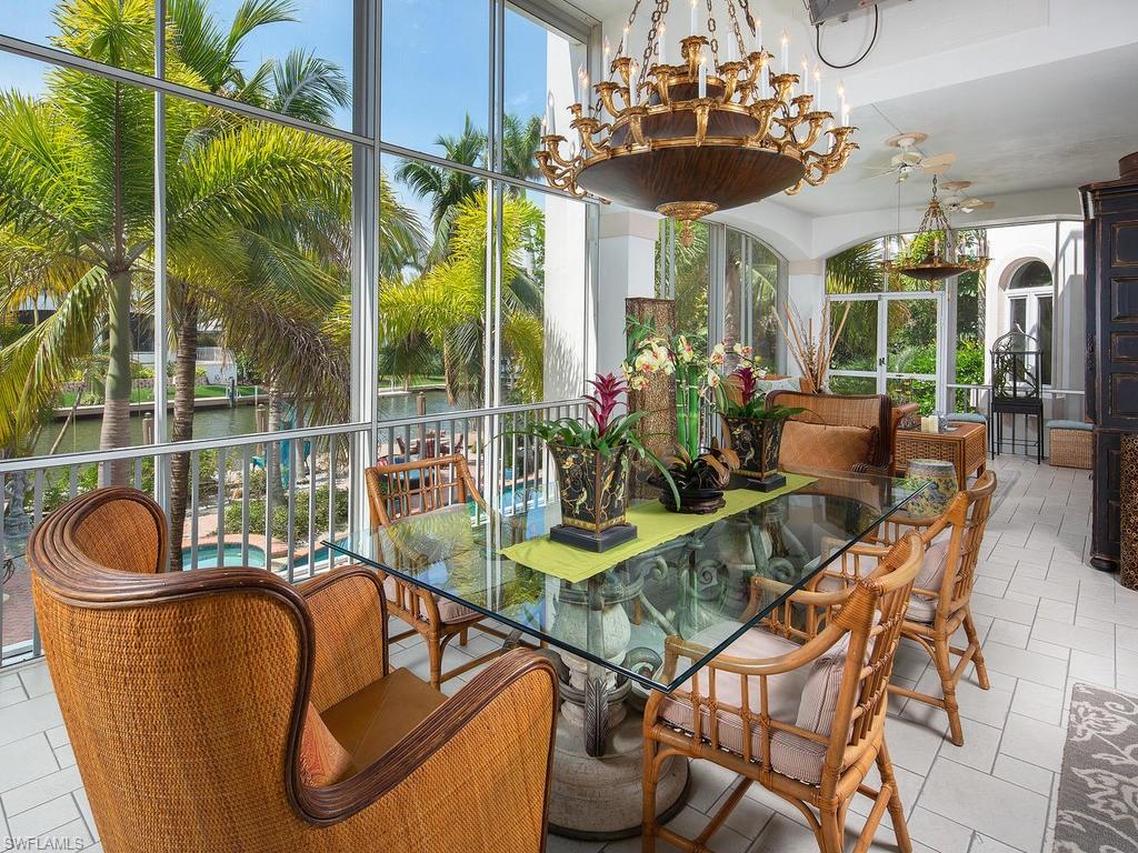 720 17th Avenue South Naples, FL 34102 - Photo 21 of 33 a view of a dining room with furniture wooden floor and chandelier