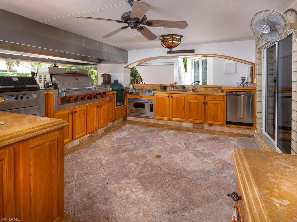 720 17th Avenue South Naples, FL 34102 - Photo 24 of 33 a kitchen with stainless steel appliances wooden cabinets and a stove