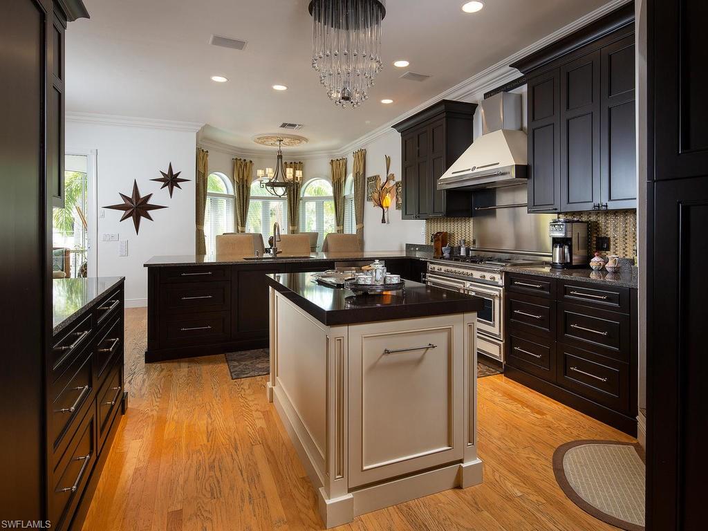 720 17th Avenue South Naples, FL 34102 - Photo 7 of 33 a kitchen with stainless steel appliances granite countertop a sink stove and cabinets