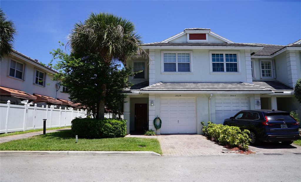 a front view of a house with a garden and plants
