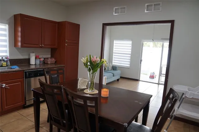 a view of a dining room with furniture and a potted plant