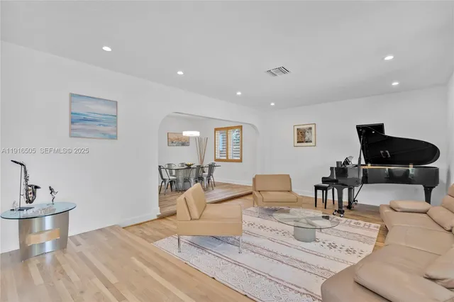 a living room with furniture and a wooden floor
