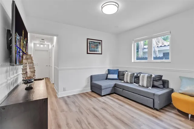 a living room with furniture and a wooden floor
