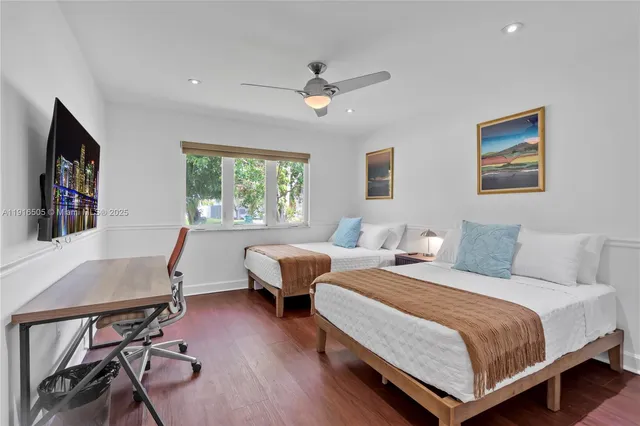 a bedroom with two beds and a desk