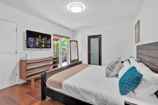 a bedroom with a bed and a wooden floor