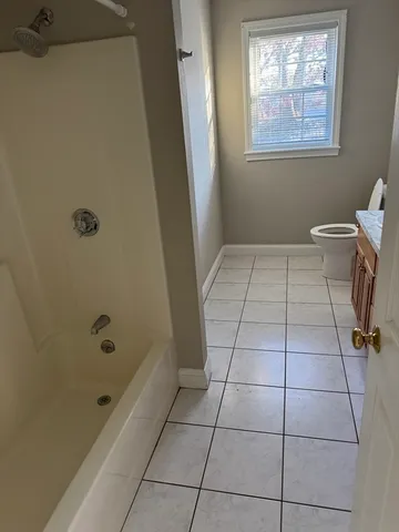a bathroom with a granite countertop sink a mirror and a bathtub
