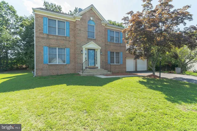a front view of a house with yard and green space