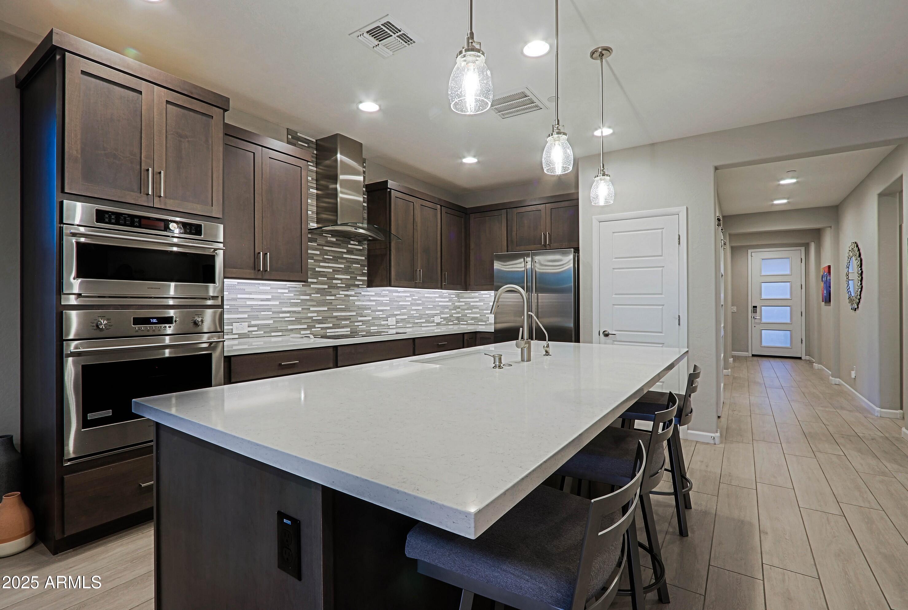 17668 East Chevelon Canyon Circle Rio Verde, AZ 85263 - Photo 15 of 59 a large kitchen with a table chairs stainless steel appliances and cabinets