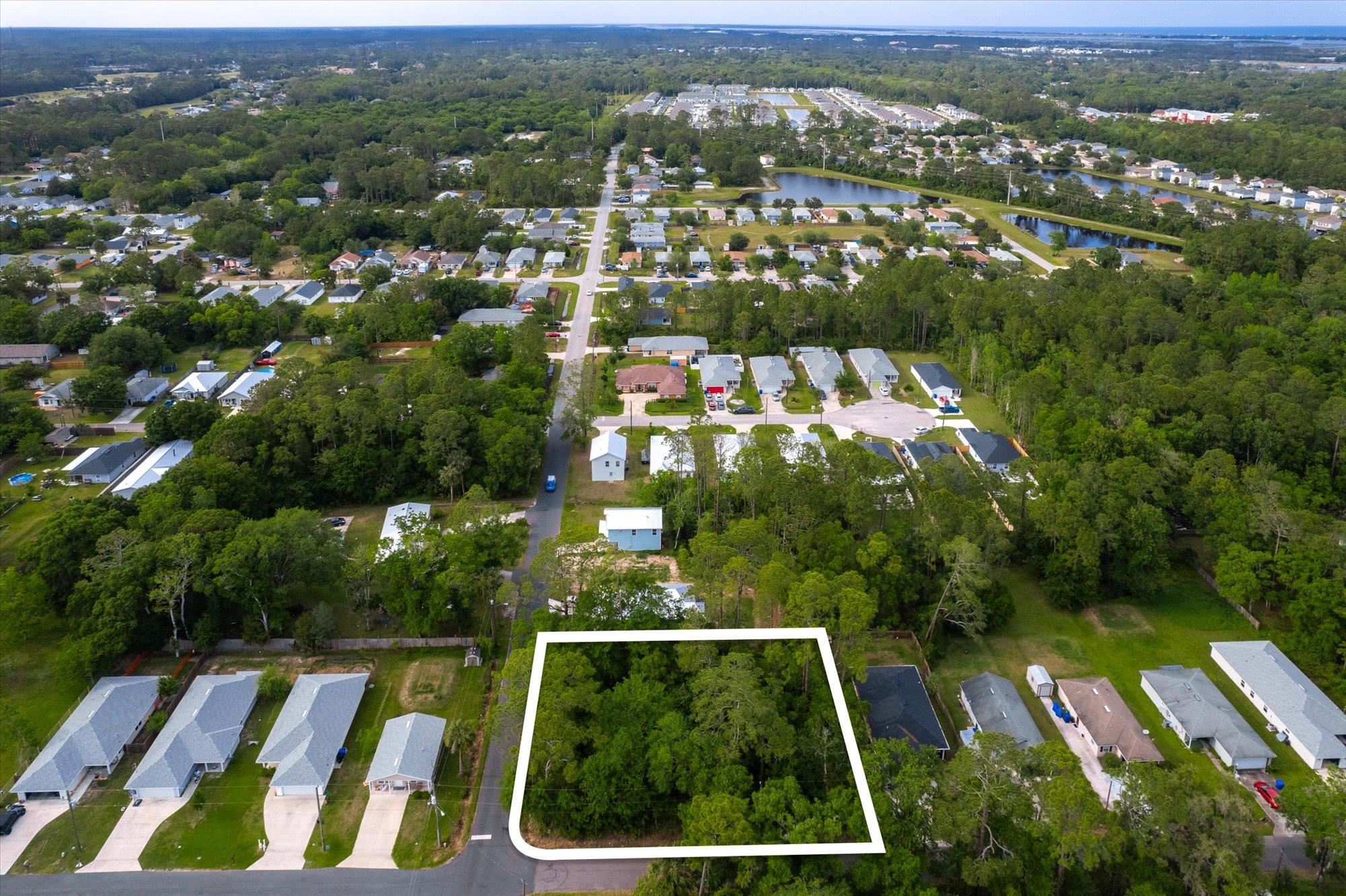 an aerial view of residential houses with outdoor space and trees