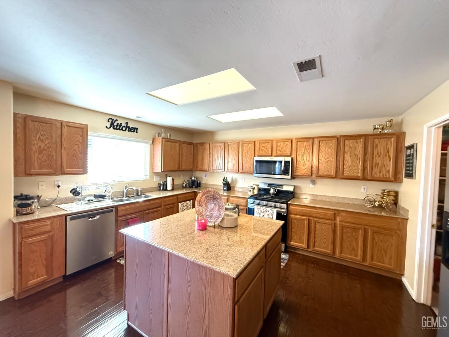 Undisclosed Address Bakersfield, CA 93311 - Photo 17 of 52 a kitchen with a stove sink and cabinets