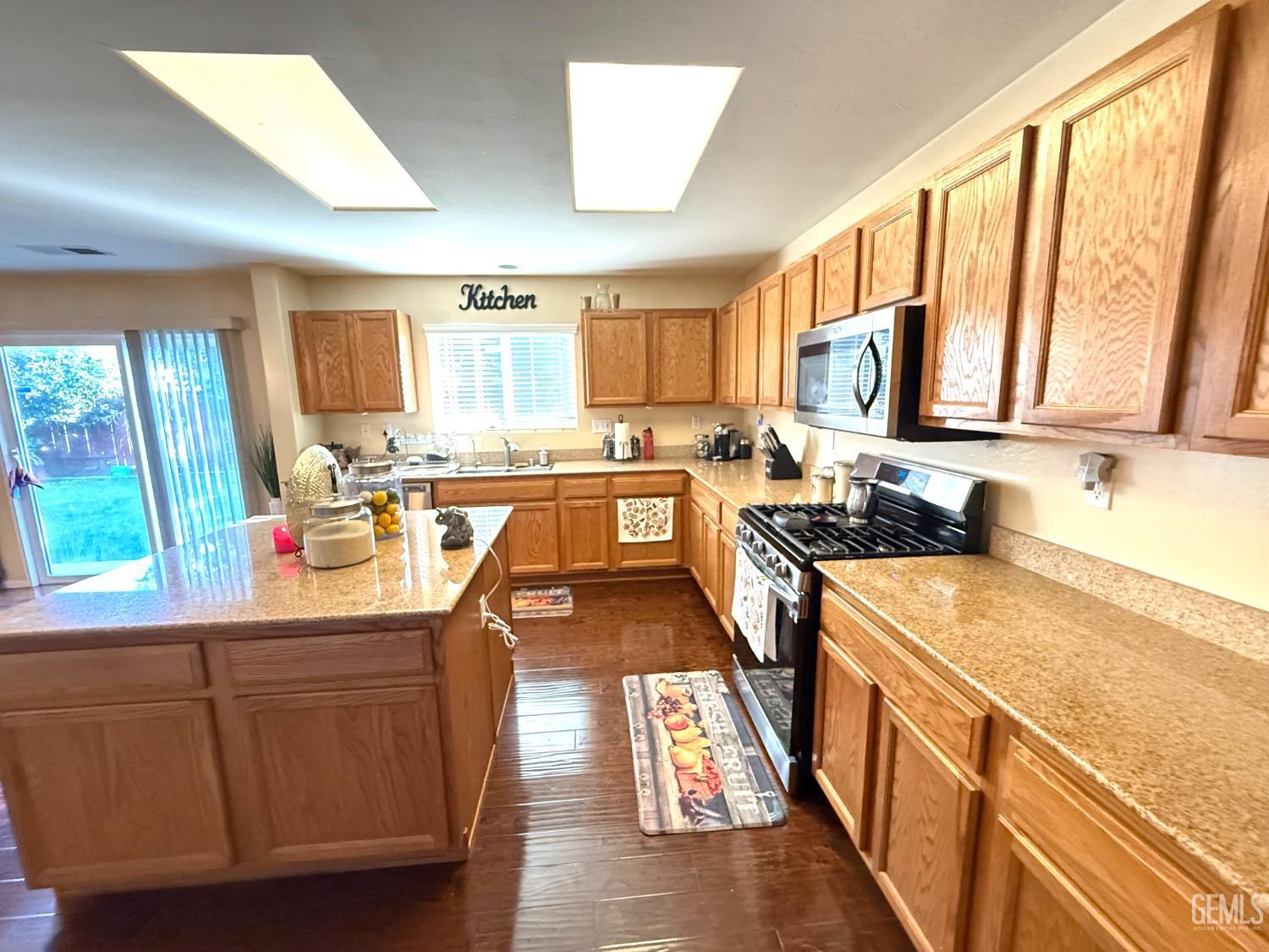 Undisclosed Address Bakersfield, CA 93311 - Photo 18 of 52 a kitchen filled counter top space a sink cabinets and appliances