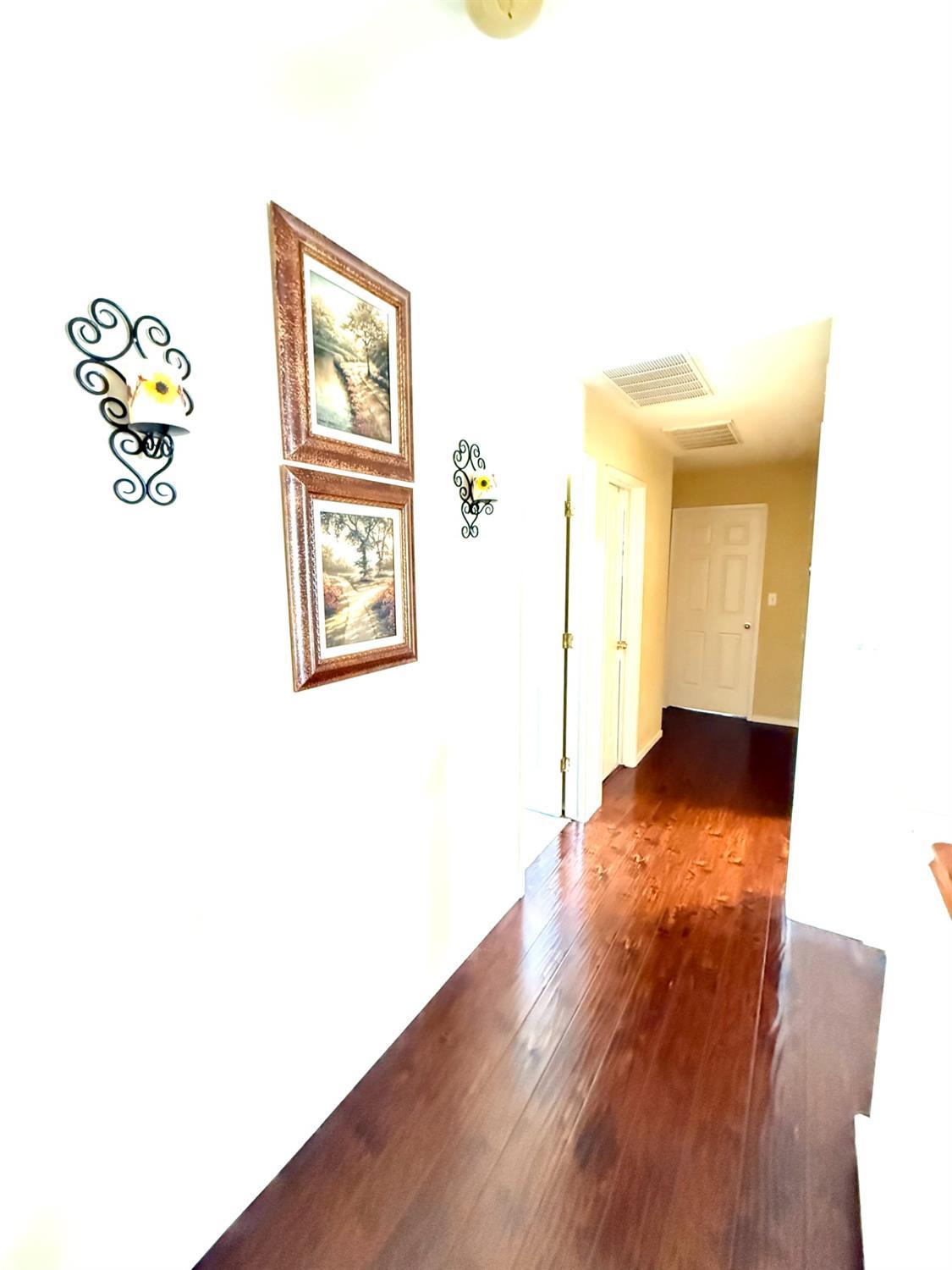 Undisclosed Address Bakersfield, CA 93311 - Photo 38 of 52 a view of a hallway with wooden floor