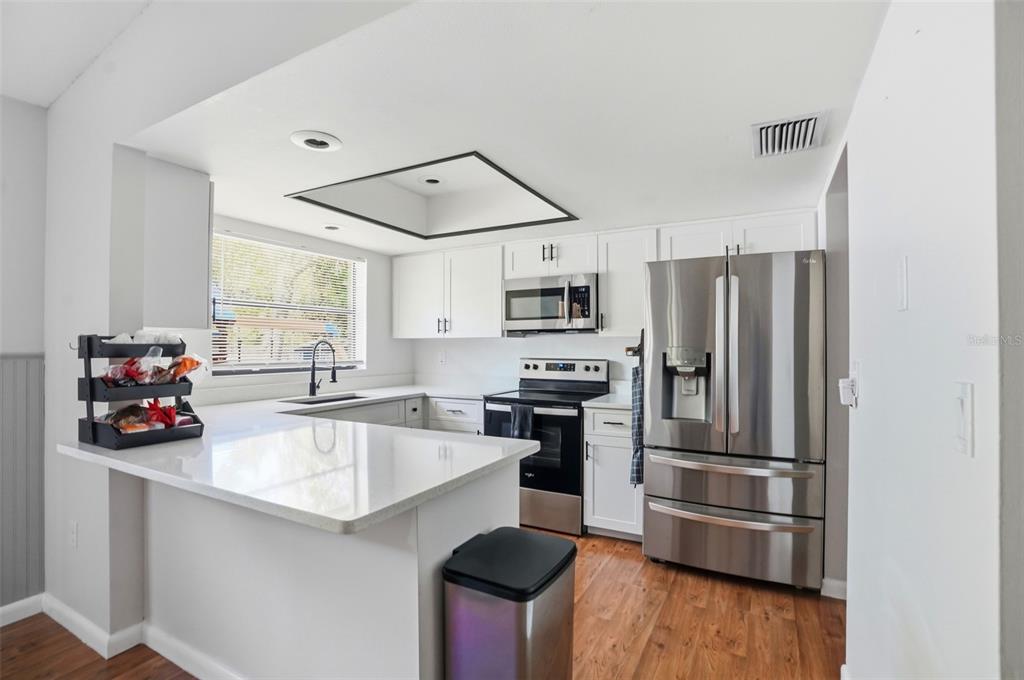 5485 Pinehurst Drive Spring Hill, FL 34606 - Photo 10 of 45 a kitchen with stainless steel appliances a refrigerator sink and microwave
