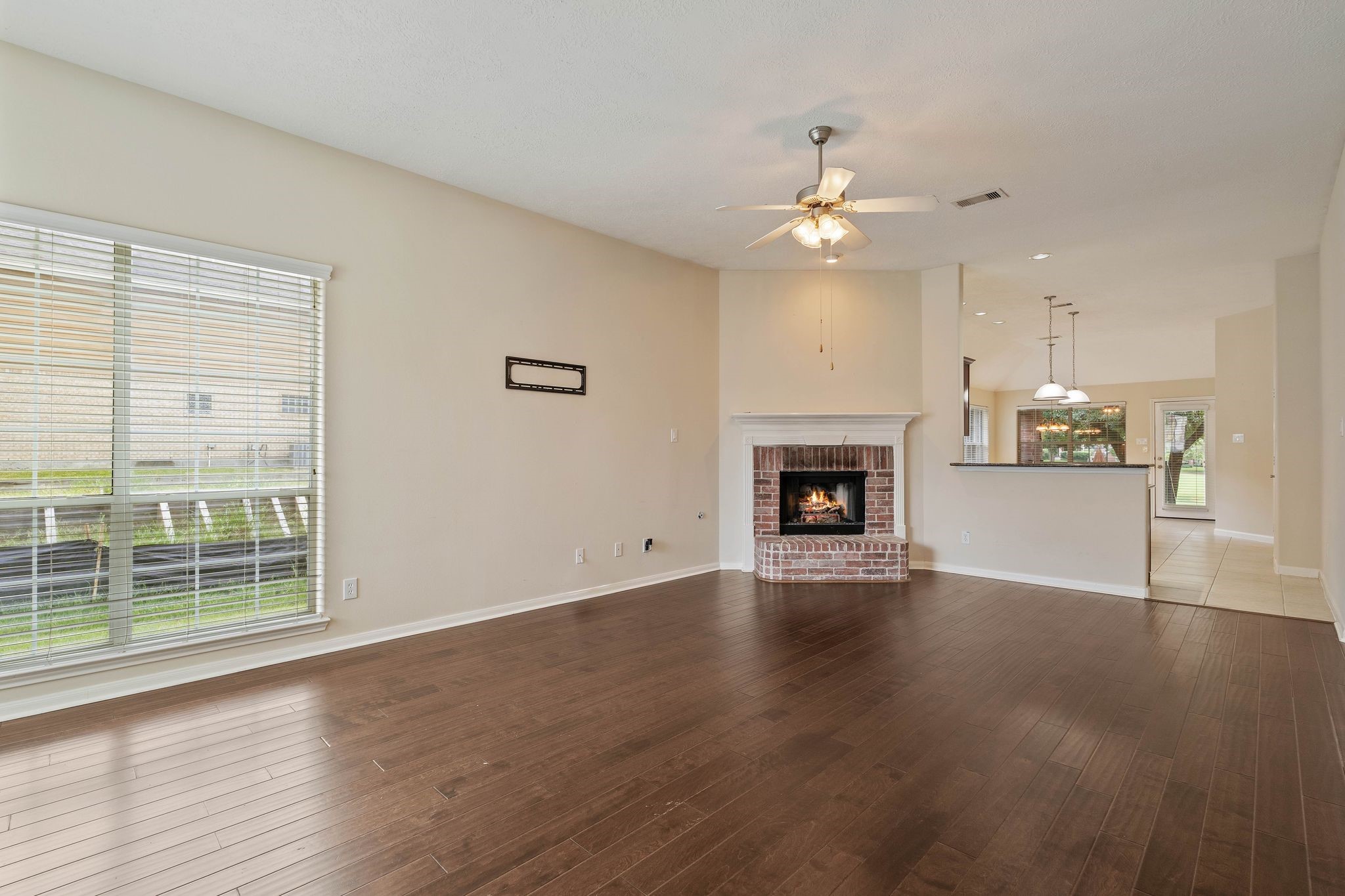 166 April Cove Montgomery, TX 77356 - Photo 7 of 37 Spacious living area featuring high ceilings, abundant natural light, and a cozy wood-burning fireplace—perfect for relaxing or entertaining.