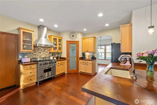 a kitchen with stainless steel appliances granite countertop sink stove and refrigerator