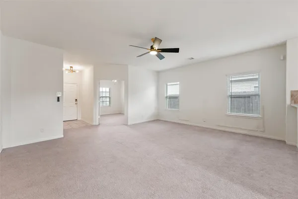 an empty room with a window and a fan
