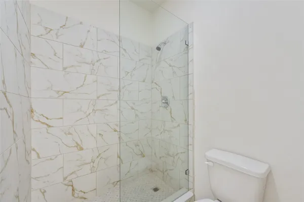 a bathroom with a bathtub shower sink vanity mirror and toilet