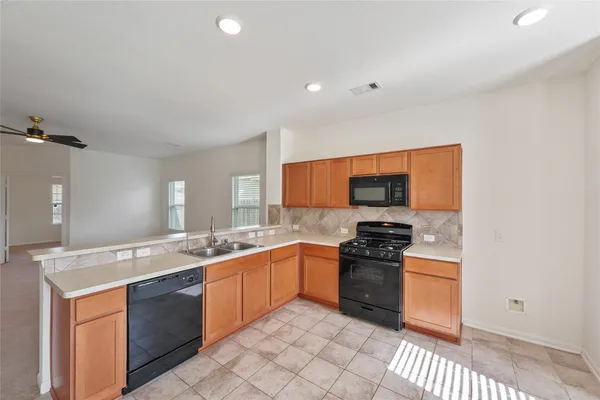 a kitchen with stainless steel appliances granite countertop a stove a sink and a refrigerator