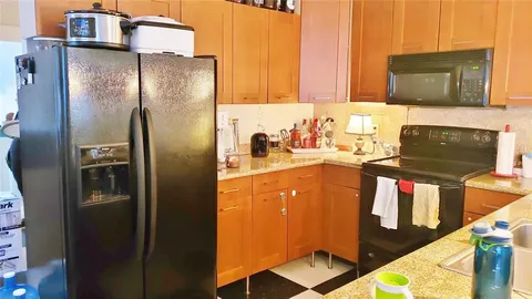 a kitchen with stainless steel appliances granite countertop a refrigerator and a stove