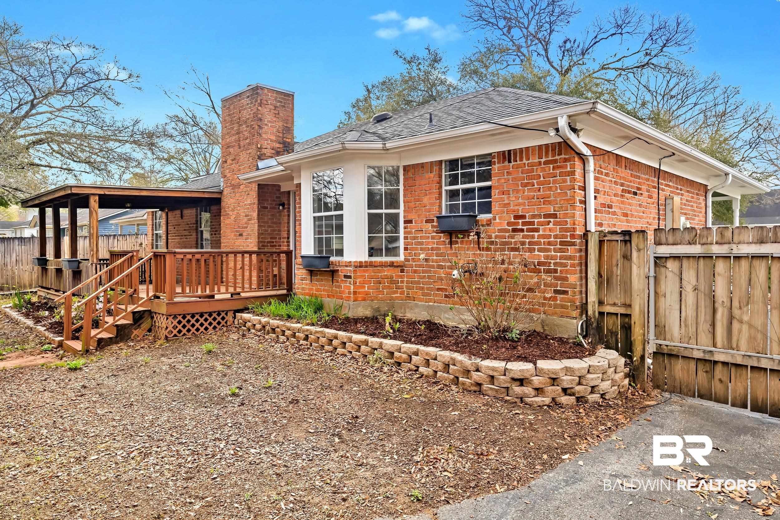 6616 Conde Court Mobile, AL 36695 - Photo 26 of 27 Exterior space featuring brick siding, a deck, a chimney, and fence