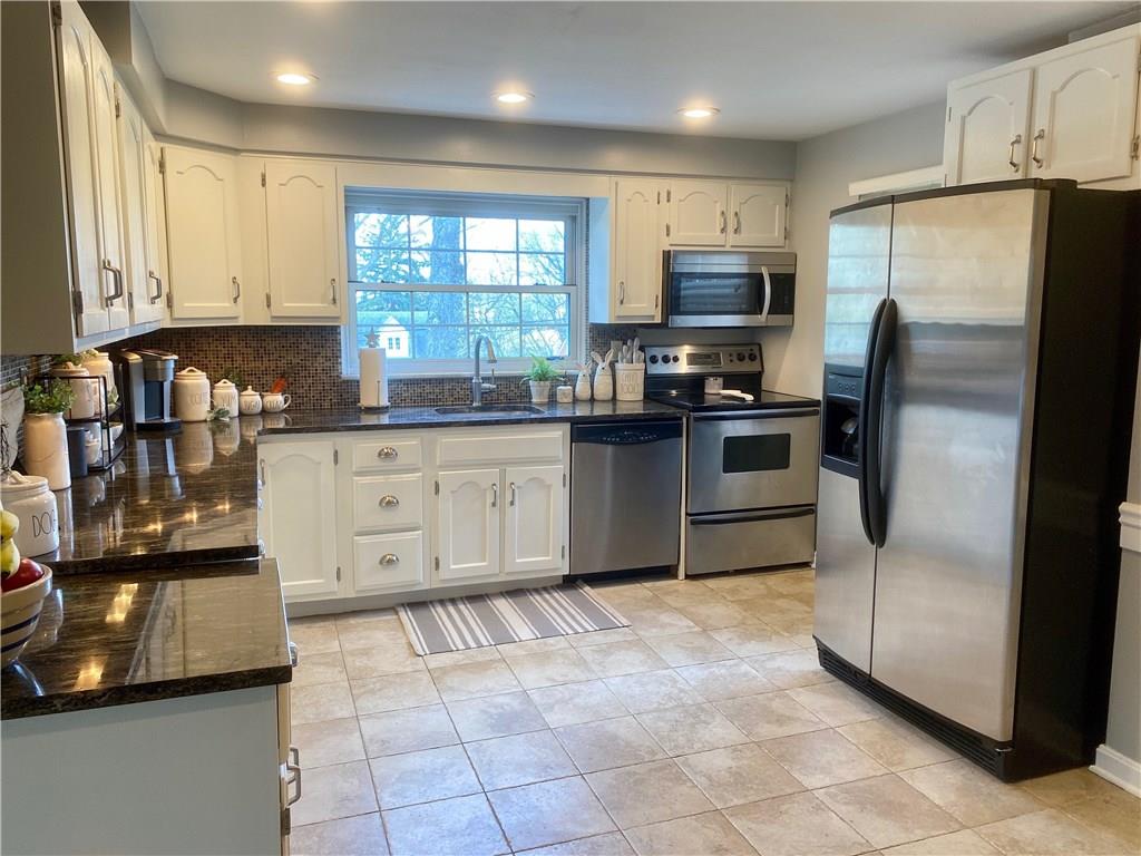 3329 Comanche Road Pittsburgh, PA 15241 - Photo 8 of 25 Equipped kitchen features stainless appliances, granite counters, recessed lighting, white cabinets, tile backsplash and tile floor.