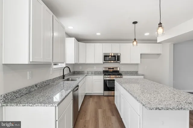 a kitchen with a sink stove top oven and cabinets