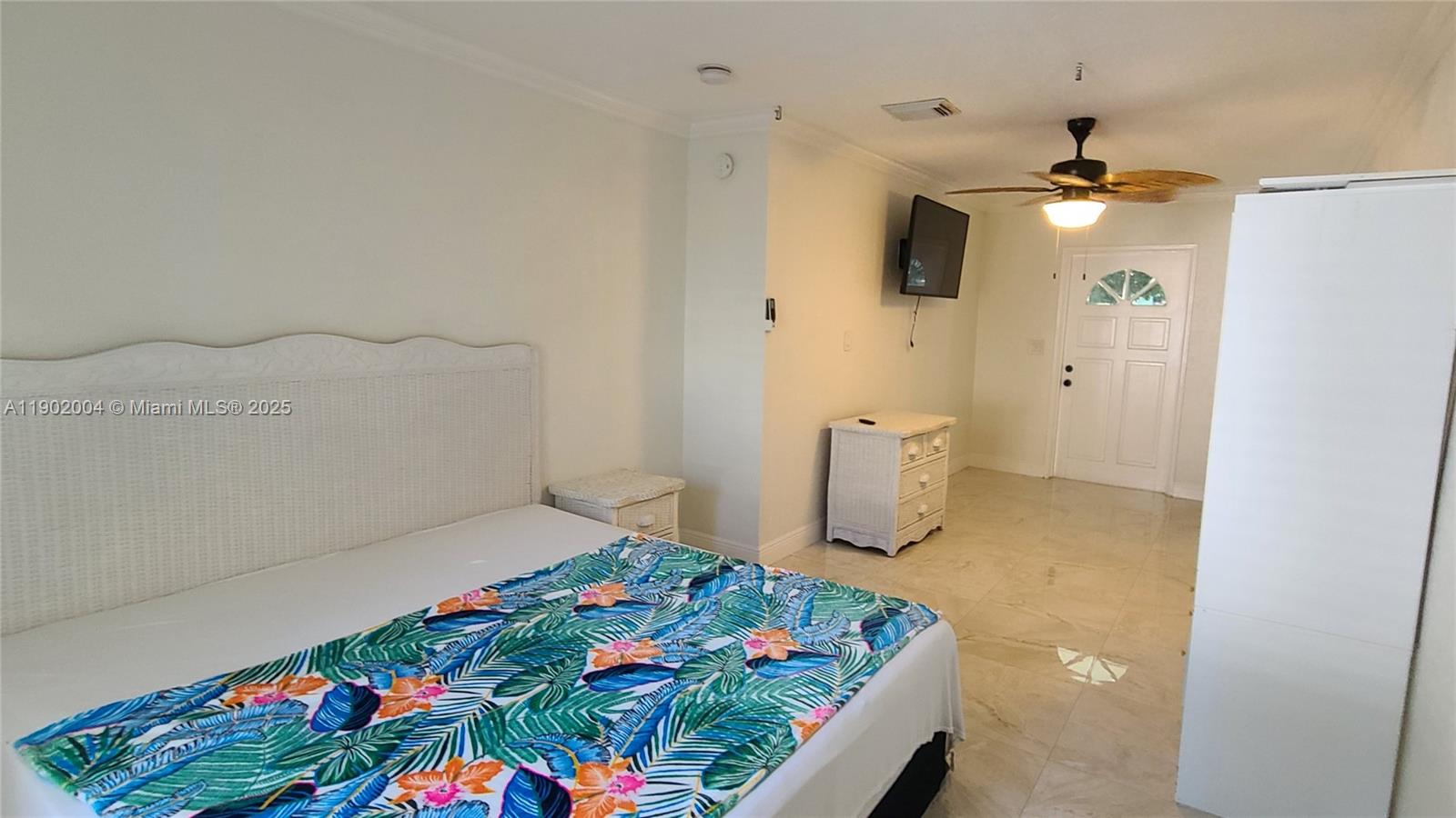 3221 Northeast 7th Street, Unit 2 Pompano Beach, FL 33062 - Photo 5 of 10 a bedroom with a bed and a chandelier