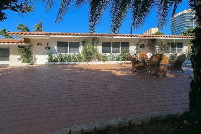 a view of a white building among the house with potted plants