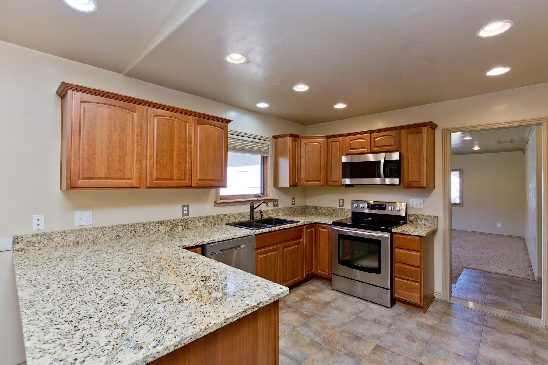 431 Pleasant Ridge Lane, Unit A Grand Junction, CO 81507 - Photo 11 of 29 a kitchen with stainless steel appliances granite countertop wooden cabinets a stove top oven a sink and dishwasher