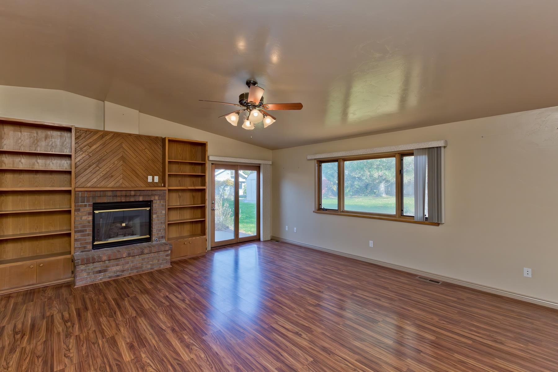 431 Pleasant Ridge Lane, Unit A Grand Junction, CO 81507 - Photo 16 of 29 an empty room with fireplace wooden floor and windows