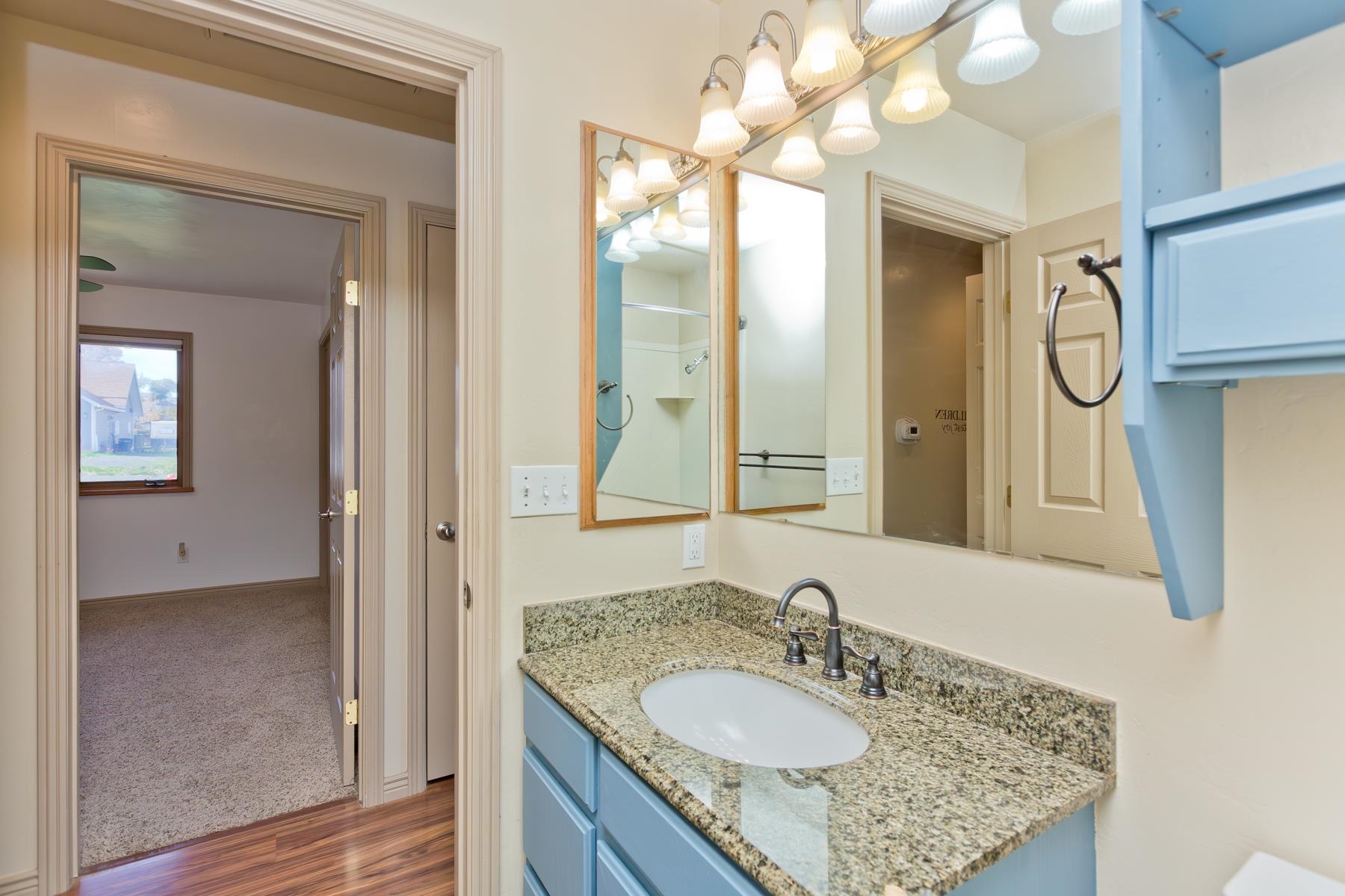 431 Pleasant Ridge Lane, Unit A Grand Junction, CO 81507 - Photo 22 of 29 a bathroom with a granite countertop sink a mirror and a shower