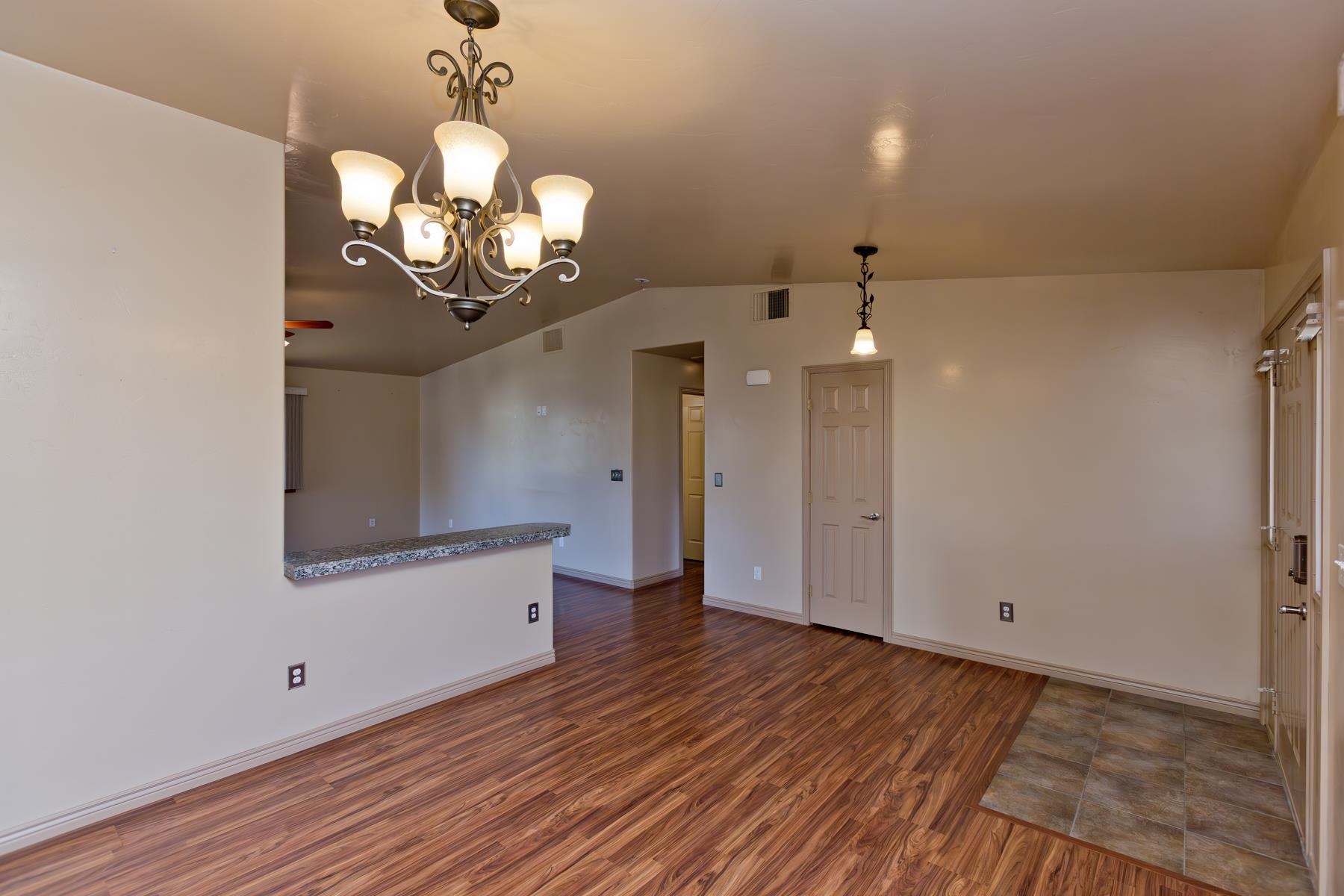 431 Pleasant Ridge Lane, Unit A Grand Junction, CO 81507 - Photo 8 of 29 a view of an empty room with wooden floor and a chandelier
