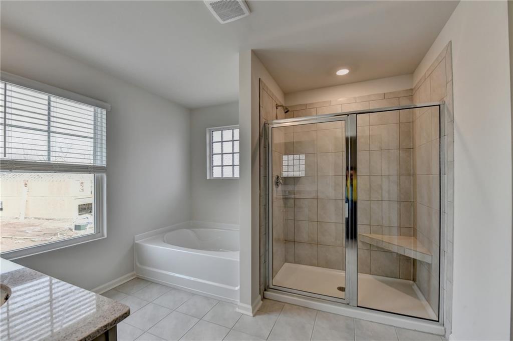4067 Peregrine Way Gainesville, GA 30506 - Photo 20 of 52 a bathroom with a bathtub and a shower