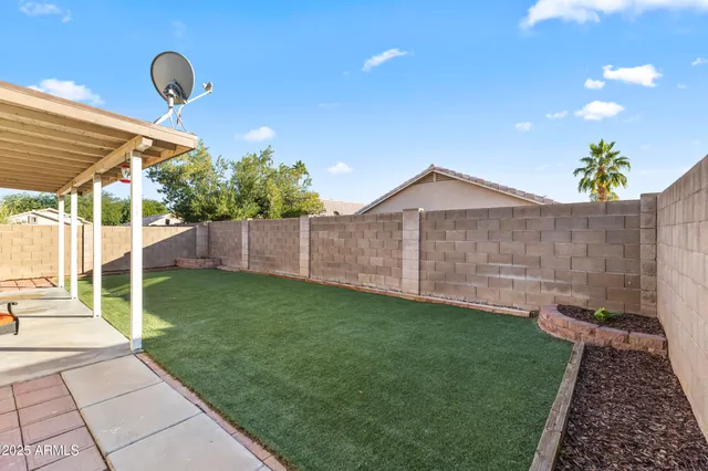 a backyard of a house with table and chairs