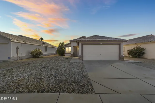 a white house with a yard and plants