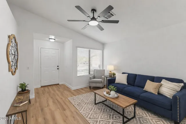 a living room with furniture and a large window with wooden floor