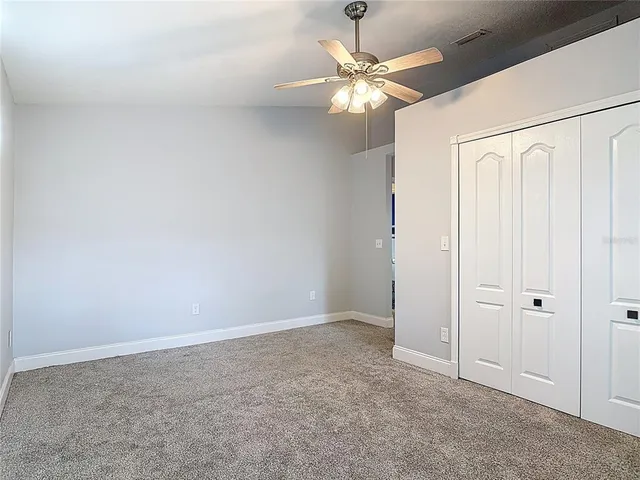 an empty room with a window and a fan