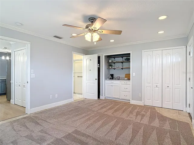 a view of a livingroom with a chandelier fan and windows
