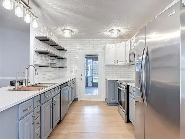 a large kitchen with cabinets and stainless steel appliances