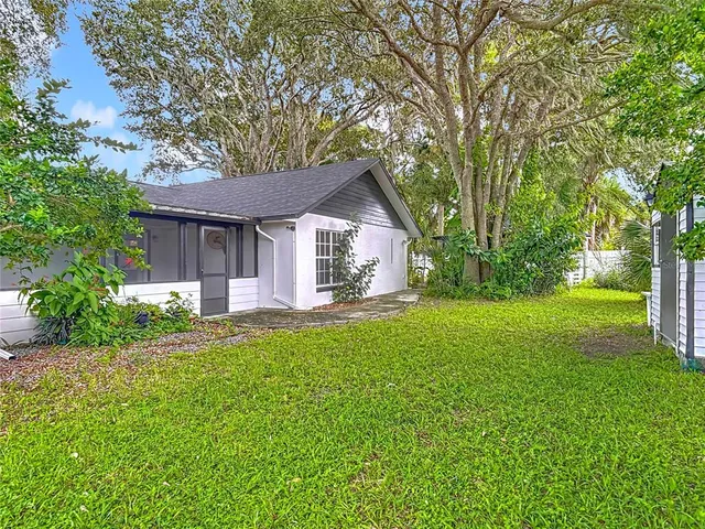 a view of a small house with backyard